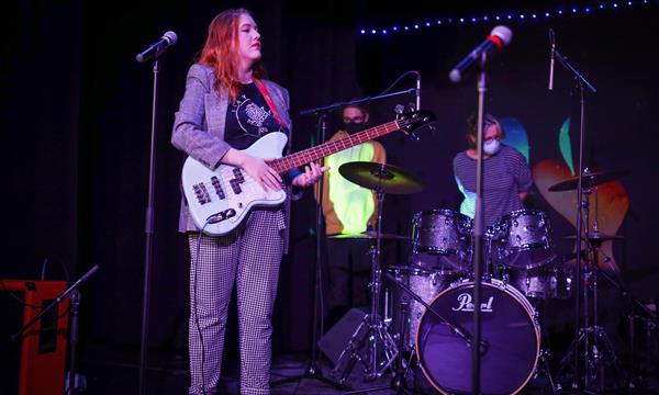 girl holds a bass and sings